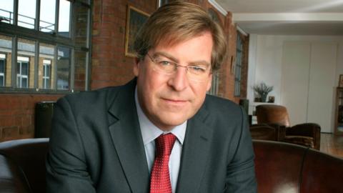 Edward Stourton pictured wearing a suit with a red tie in 2005