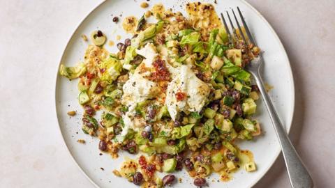 A white plate topped with various diced vegetables in a golden sauce, topped with a dollop of stracciatella.