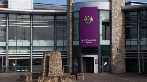 The entrance of North Somerset Magistrates' Court with a purple sign above the door