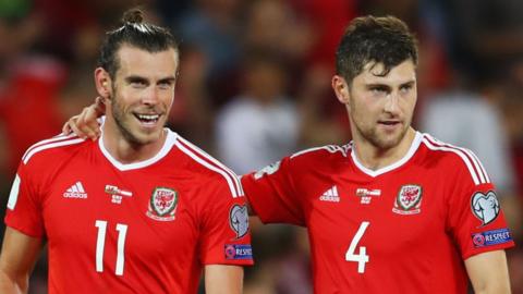 Ben Davies (right) has an arm around a smiling Gareth Bale during a Wales game