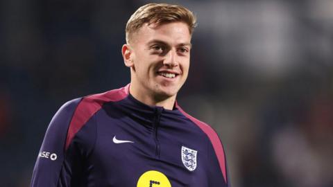 Liam Delap smiling in an England training top