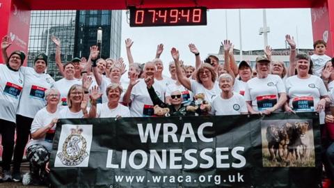 A team of elderly men and woman posing at the finish line