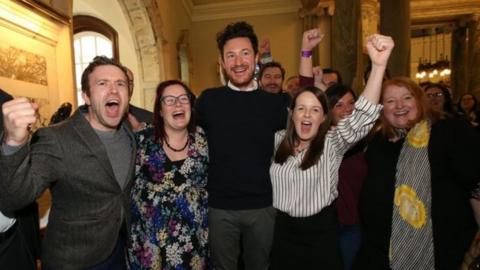 Alliance's Ross McMullan (centre) celebrates his election