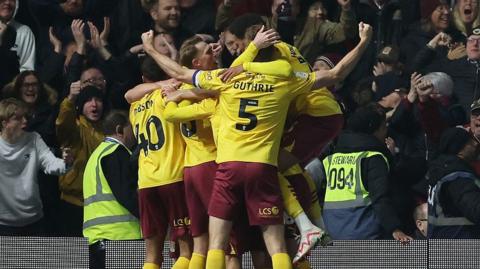 Northampton players celebrate in front of the away end after their late equaliser at Birmingham