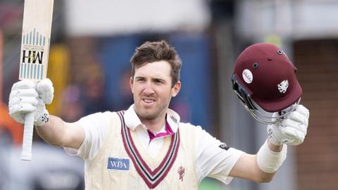 Craig Overton with helmet in one hand and bat in the other to acknowledge a century
