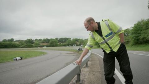 man pointing at abrasive mark on a barrier 