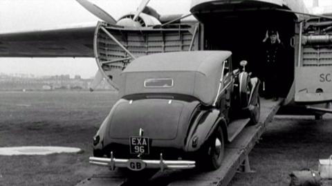 A car is loaded onto a plane.