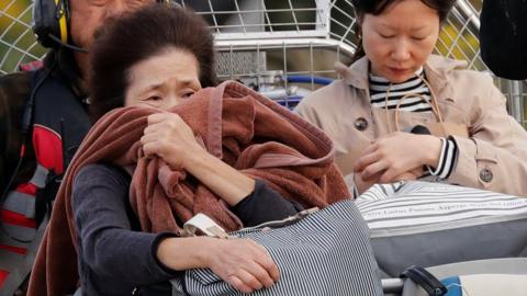 A woman reacts after she was rescued from a flooded area in the aftermath of Typhoon Hagibis