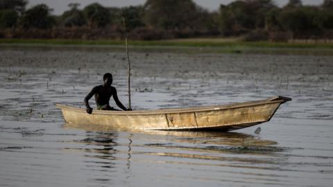 A lone fisherman steers his boat on Lake Chad