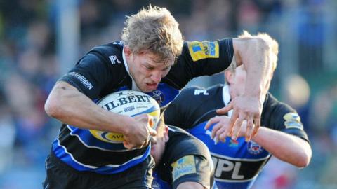 Image of Lewis Moody mid run on the rugby pitch. He's wearing the Blue and Black rugby kit and running with the ball. 
