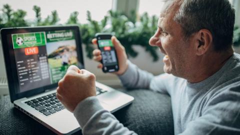 Man betting on his smartphone