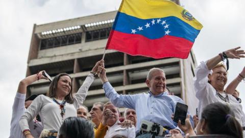 Opposition presidential candidate Edmundo González (centre) waves a Venezuelan flag in July 2024