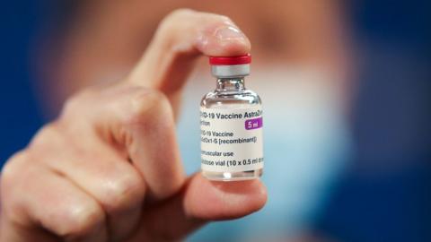 Healthcare worker holding a vial of the AstraZeneca vaccine