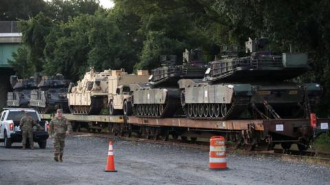 Two M1A1 Abrams tanks and other military vehicles sit on guarded rail cars at a rail yard on July 2, 2019 in Washington, DC