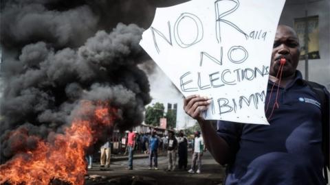 An opposition supporter holds a placard during a protest against Independent Electoral and Boundaries Commission (IEBC) in Kisumu, Kenya, on 11 October 2017