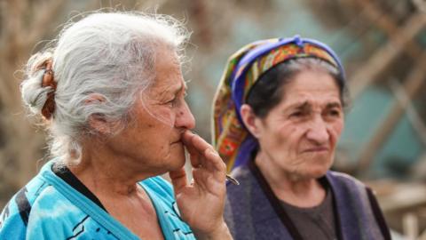 Women by destroyed house in Azerbaijan