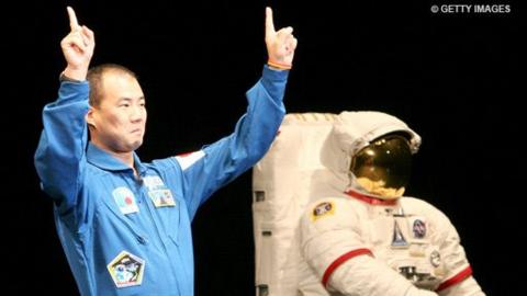 Japanese astronaut Soichi Noguchi attends a debrief session onstage next to a space suit in Tokyo, Japan.