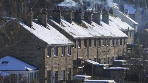 A row of terraced houses with chimneys on a frosty winter's day.