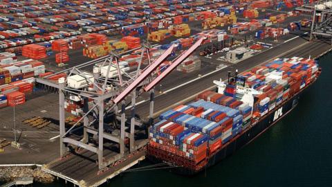 Shipping containers being lifted by a crane at Los Angeles docks onto a tanker