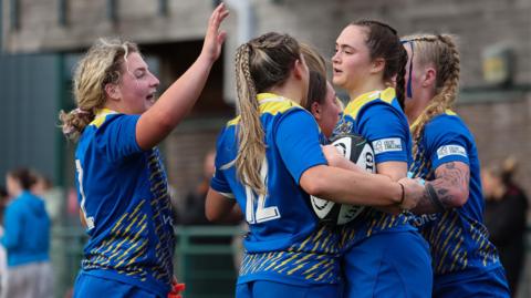 Caitlin Lewis celebrates a try with Gwalia Lightning team mates