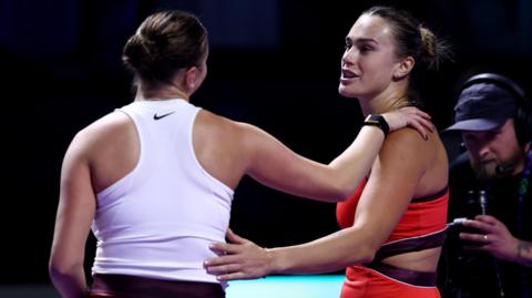 Aryna Sabalenka and Amanda Anisimova embrace at the net after their match