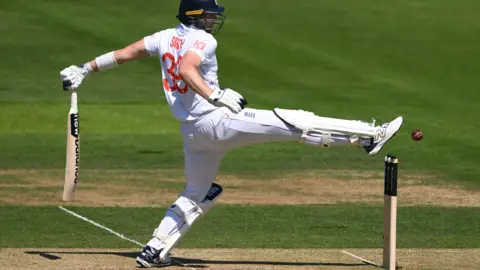 England batter Jamie Smith tries to kick the ball away from his stumps