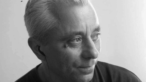 Black and white headshot picture of a man looking into the distance 