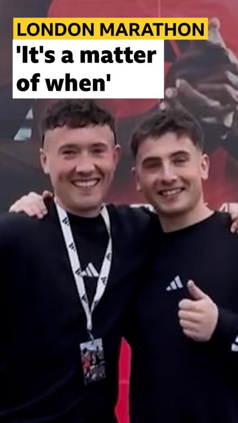 Jordan Adams and Cian Adams side by side in a running race, smiling to camera with their thumbs up 