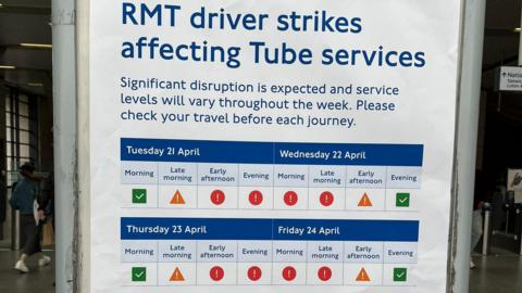 A poster at a tube station titled "RMT driver strikes affecting Tube services" detailing significant travel disruption. It features a colour-coded calendar for Tuesday 21 April through Friday 24 April, indicating service levels across morning, afternoon, and evening time slots using green ticks, yellow caution triangles, and red exclamation marks.