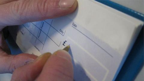 A person writing a cheque