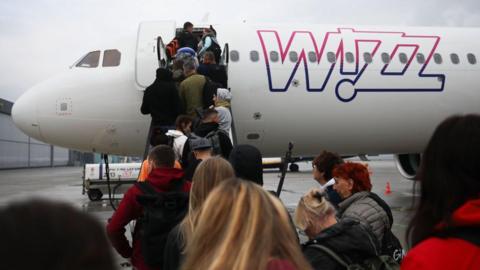 Passengers board a Wizz Air plane