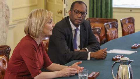 Liz truss and Kwas Kwarteng sit at a table