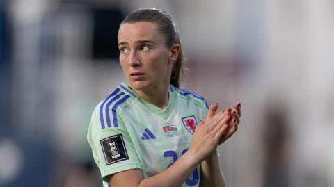 A dejected Carrie Jones applauds the travelling crowd