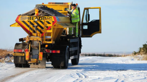A gritter being checked by its driver on North Yorkshire's uplands which are covered with snow and ice.