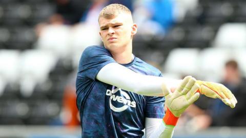 Ben Hughes goes through some stretching exercises in the warm-up ahead of a game