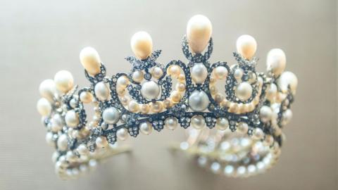 Close up photo of ornate pearl and diamond tiara worn by Empress Eugenie as displayed at the Louvre Museum, Paris