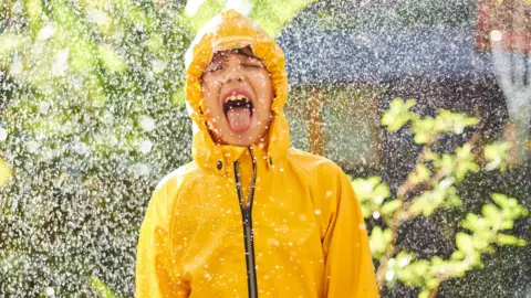 child with tongue out tasting rain 