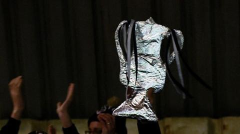 A fan holds up an FA Cup replica trophy