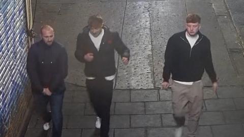 CCTV of three men wearing dark jackets