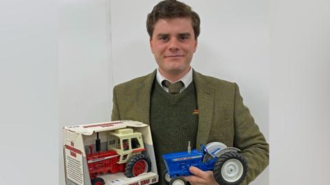 Henry Hyde with two of the toy tractor models