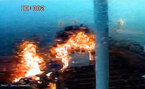 Grainy CCTV image showing two large balls of fire engulf an oil tanker after it is hit from the side by a blue cargo ship. 