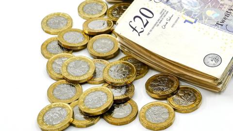 22 1 pound coins and a stack of 20 pound notes