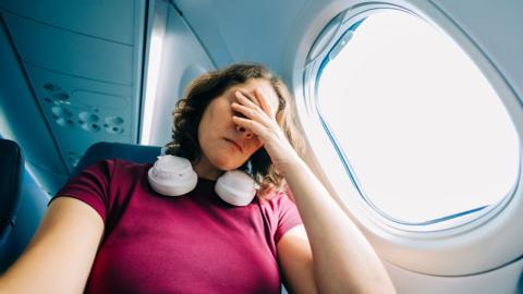 Woman feeling stress during an airplane flight - stock photo
