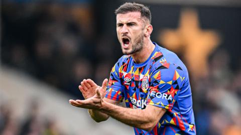 Dom Ball claps his hands to encourage his Cambridge team-mates