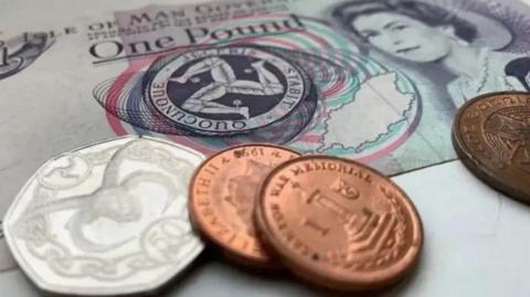 Manx coins laid on top of a Manx £1 note.