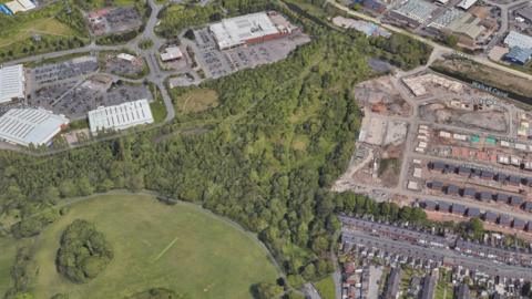 An aerial view of a large expanse of woodland between urban areas on a map.