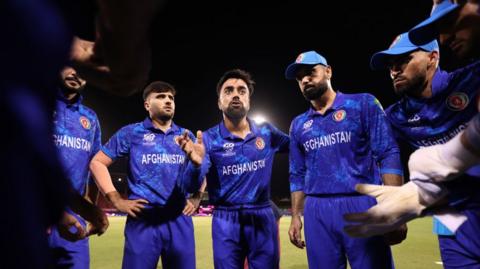 Afghanistan cricketer Rashid Khan speaks to his players in a huddle 