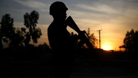 An Afghan soldier stands guard at the scene of a bomb blast that targeted vehicle of security officials in Jalalabad, Afghanistan, 11 February 2021