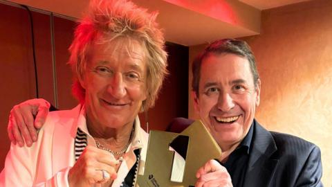 Sir Rod Stewart and Jools Holland holding their number one chart trophy