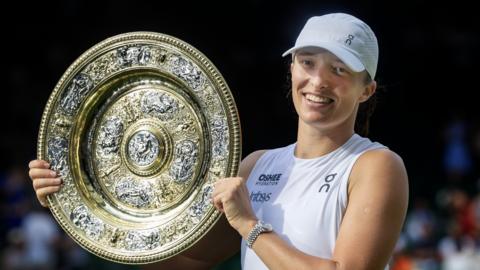 Iga Swiatek poses with the Wimbledon trophy